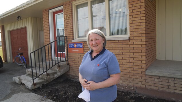 Une femme devant un bureau de poste.