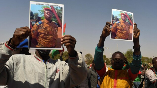 Des manifestants portant la photo d'un militaire