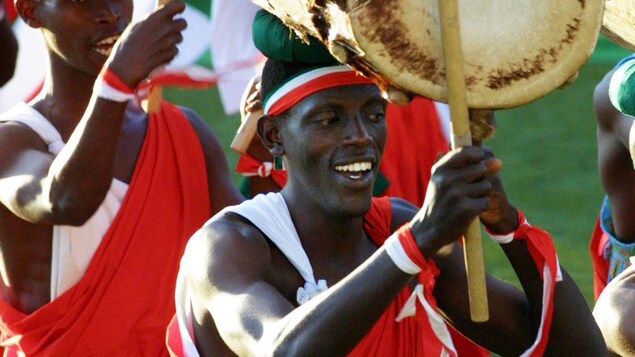 Des athlètes défilent en jouant des percussions