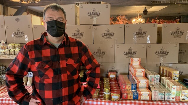 Richard Lessard se tient devant une table pleine de produits de l'érable.