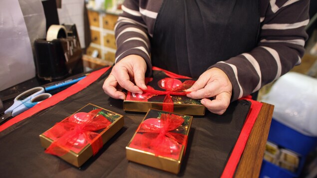 Une personne emballe un cadeau