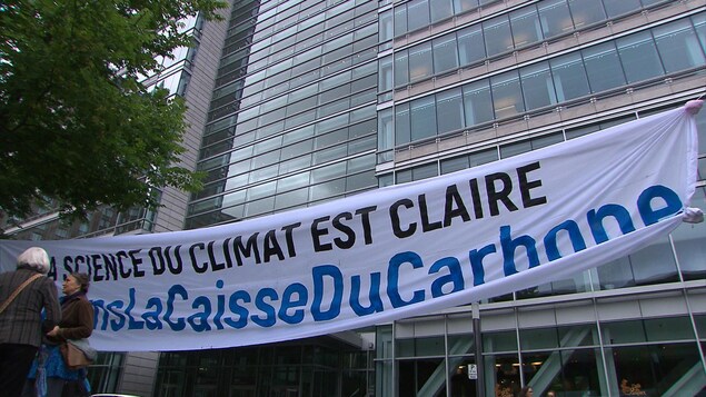 Une banderole sur laquelle il est écrit: « La science du climat est claire #SortonsLaCaisseDuCarbone », devant les bureaux de la Caisse de dépôt et placement du Québec à Montréal Une banderole sur laquelle il est écrit: « La science du climat est claire #SortonsLaCaisseDuCarbone », devant les bureaux de la Caisse de dépôt et placement du Québec à Montréal