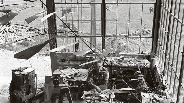 Entouré de ses mobiles, Alexander Calder prend la pose dans son atelier de Roxbury dans le Connecticut, en 1941 Entouré de ses mobiles, Alexander Calder prend la pose dans son atelier de Roxbury dans le Connecticut, en 1941