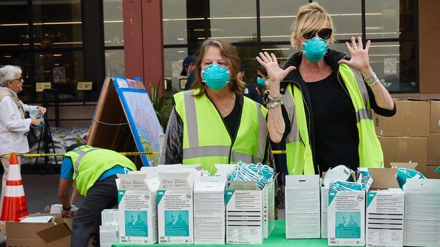 Des femmes présentes à un point de distribution de masques respiratoires en Californie. Des femmes présentes à un point de distribution de masques respiratoires en Californie.