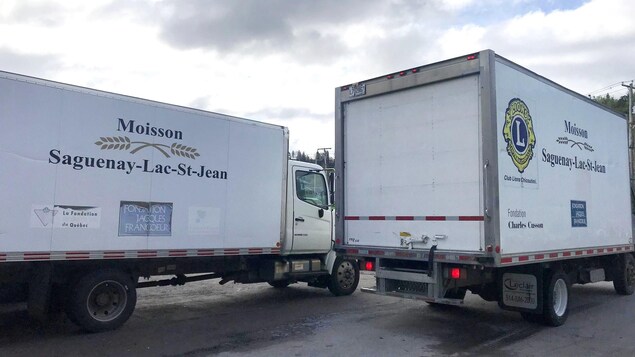 Des camions de Moisson Saguenay-Lac-Saint-Jean stationnés.