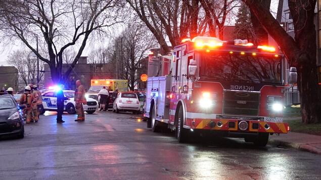 Un camion de pompier et une ambulance en bordure de la rue.
