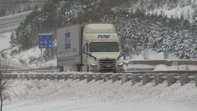 Un camion sur une route enneigée.