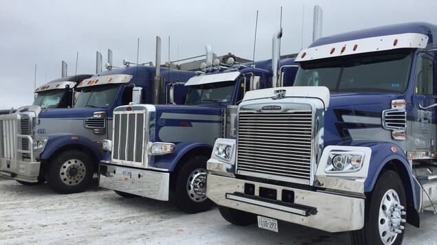 Des camions stationnés un à côté de l'autre.