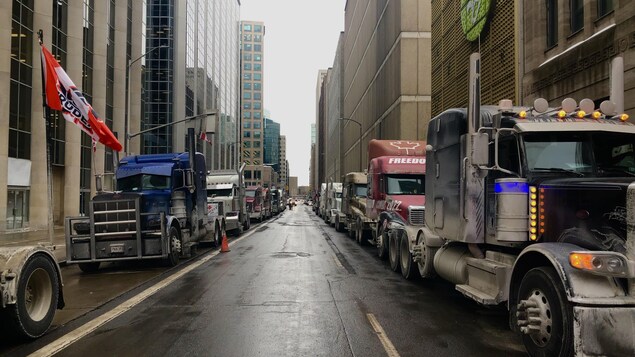 Des camions sont stationnés en bordure d'une rue du centre-ville d'Ottawa, au sixième jour de la mobilisation. 