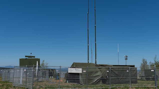 Camp militaire derrière une clôture.