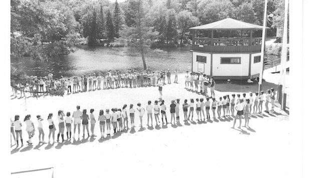 Une photographie datant de 1983 montre des adolescents en cercle autour du mirador du camp.