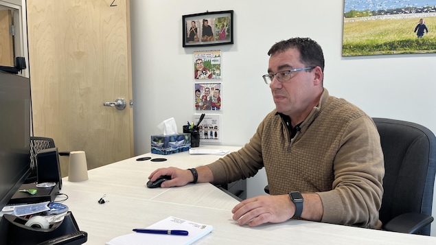Yanick Baillargeon est assis à son bureau.