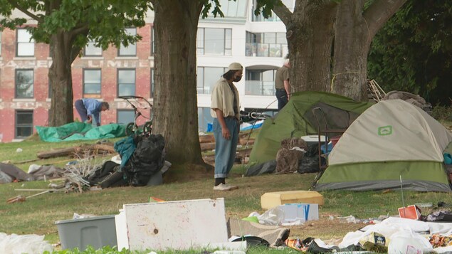 Un homme se tient devant sa tente.