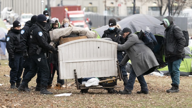 Des policiers déménagent une base de lit.