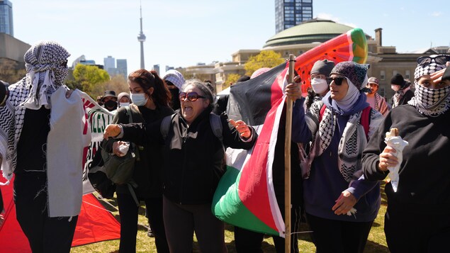 Des manifestants tiennent des drapeaux palestiniens à l'Université de Toronto, le 2 mai 2024.