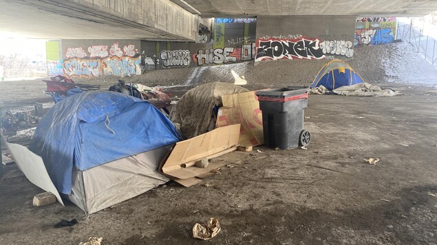 Des tentes sous une structure de béton.