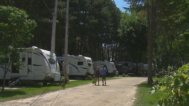Deux personnes marchent dans un camping.