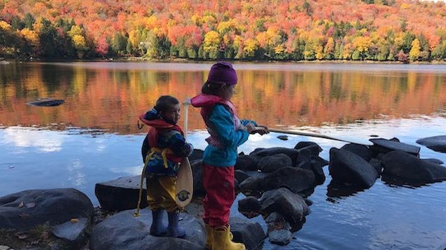 Mélane, 11 ans, et Zakaël, 7 ans, pêchent sur le bord d'un lac