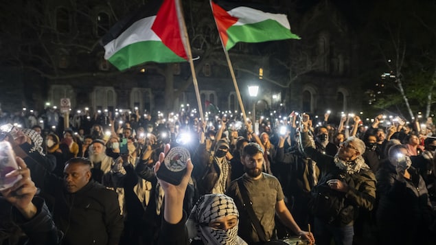 Des manifestants tiennent des drapeaux palestiniens.