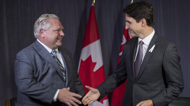 Doug Ford et Justin Trudeau se serrent la main.