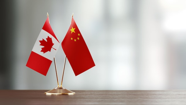 Deux drapeaux côte à côte : celui de la Chine et celui du Canada.