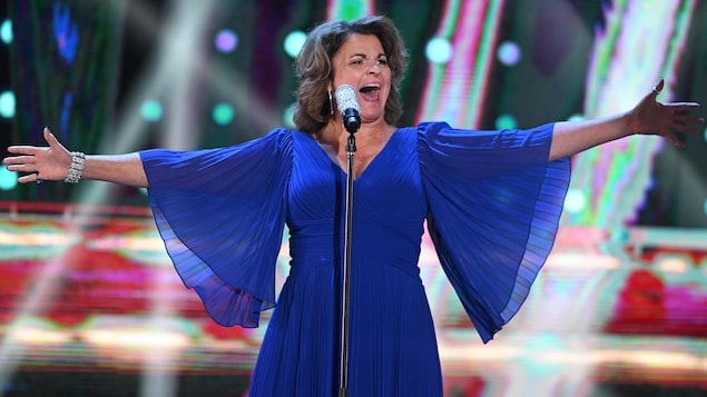 Jeanick Fournier chante avec une robe bleue.