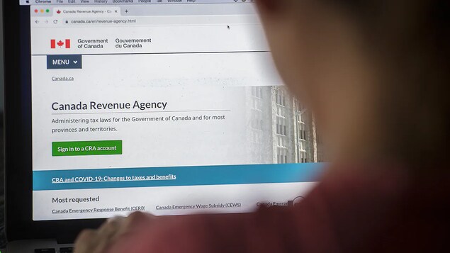 Nakaharap ang isang tao sa laptop at sa screen nito makikita ang website ng Canada Revenue Agency.