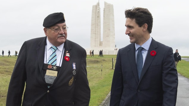 Le premier ministre parle avec un ancien combattant devant le mémorial national du Canada à Vimy.