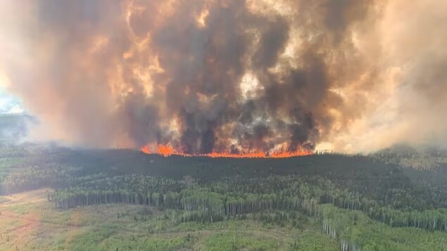 Smoke rises from the Bald Mountain Fire in the Grande Prairie Forest Area near Grande Prairie, Alta., on May 12. The fires could cut into consumer confidence, said one economist, as could a round of economic warnings from banks and government officials. (Alberta Wildfire/Handout via Reuters)