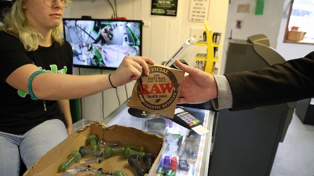 Une employée de FunkyPiece remet gratuitement à un client du cannabis pour l'achat d'une pipe en verre à 15 $. Une employée de FunkyPiece remet gratuitement à un client du cannabis pour l'achat d'une pipe en verre à 15 $.
