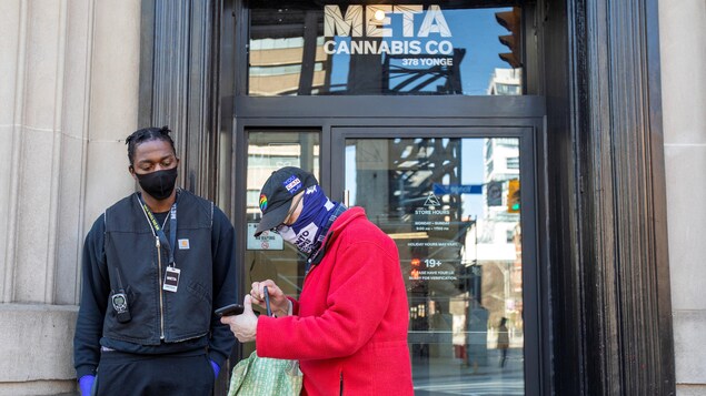 Un client et un vigile à la sortie d'un magasin de cannabis. 