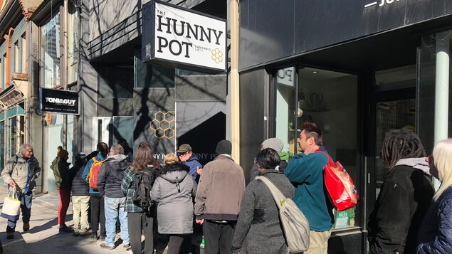 Des gens font la queue devant un magasin de cannabis.