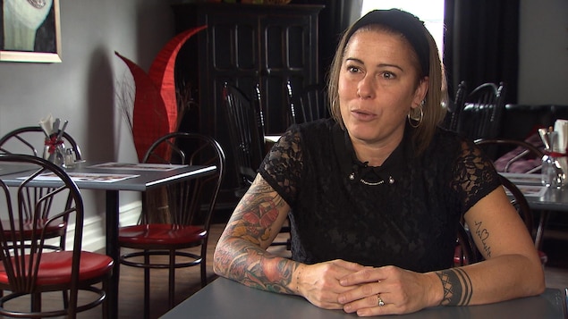 Geneviève Cadrin assise à table, à son resto-pub La Maîtresse.