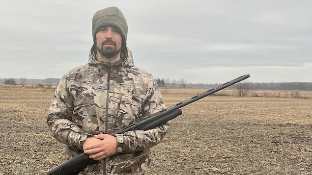 Carey Price est photographié dans un champ, en habit de chasseur et tient dans ses mains une arme à feu.