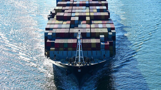 Un navire transporte des cargos en naviguant sur un plan d'eau.