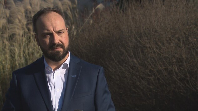 Carl Boisvert devant des arbustes.