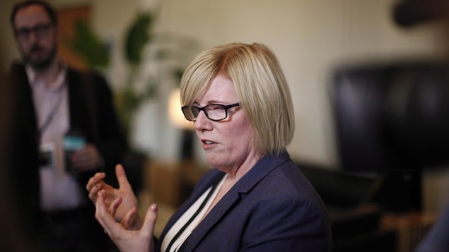 La ministre Qualtrough est une femme blonde, qui porte des lunettes aux montures noires, épaisses.