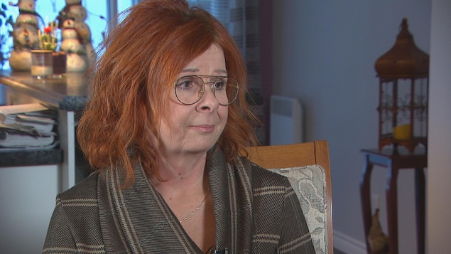 Un femme discute à une table avec une journaliste.