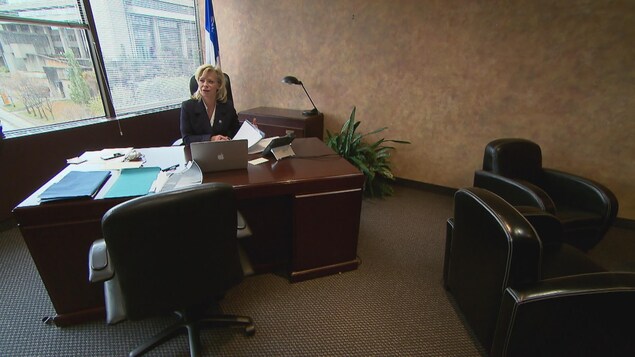 Caroline Proulx est assise à son bureau. Caroline Proulx est assise à son bureau.