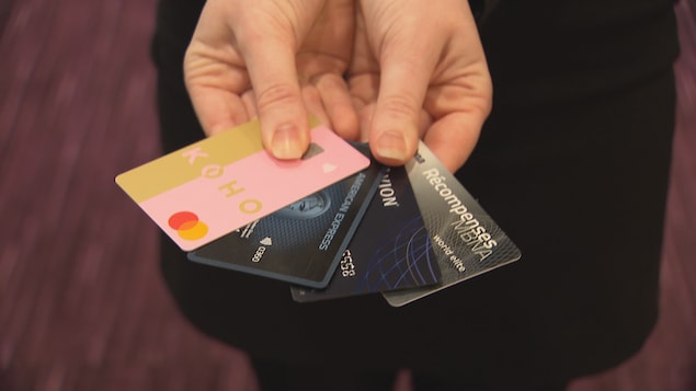Une personne tient quatre différentes cartes de crédit. 