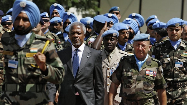 Kofi Annan marche en compagnie d'un général à travers les soldats de la FINUL.