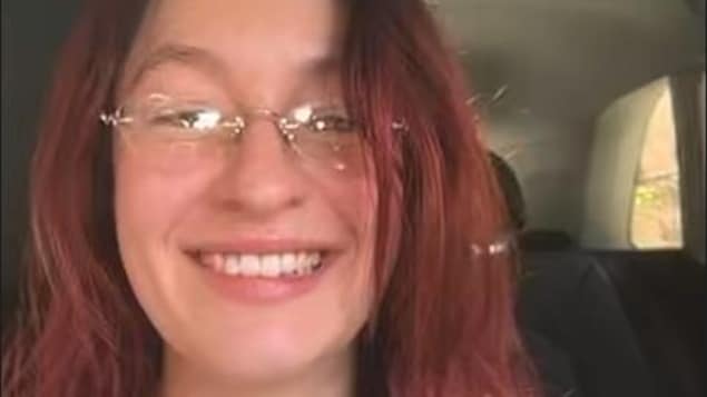 Une personne souriante dans une voiture en vidéoconférence.