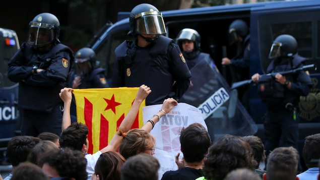 Un manifestant brandit le drapeau de l'indépendance catalane devant des policiers espagnols, à Barcelone. Un manifestant brandit le drapeau de l'indépendance catalane devant des policiers espagnols, à Barcelone.
