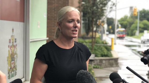 Catherine McKenna prend la parole devant son bureau.