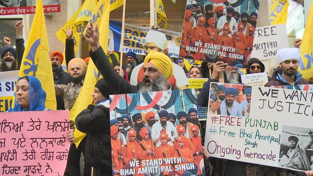 Un groupe de manifestant brandit des pancartes demandant la fin de la répression dans la région du Penjab, en Inde, devant le consulat général de ce pays à Vancouver, le samedi 25 mars 2023.
