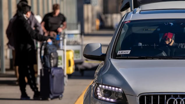 Une voiture portant un autocollant Uber attend un client au terminal des arrivées de l'aéroport international de Vancouver (YVR).