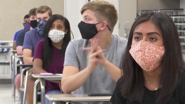 Des étudiants collégiaux portent le masque en classe. 