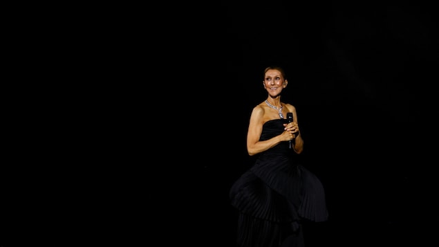 Céline Dion sourit sur scène lors de son premier concert à Paris.
