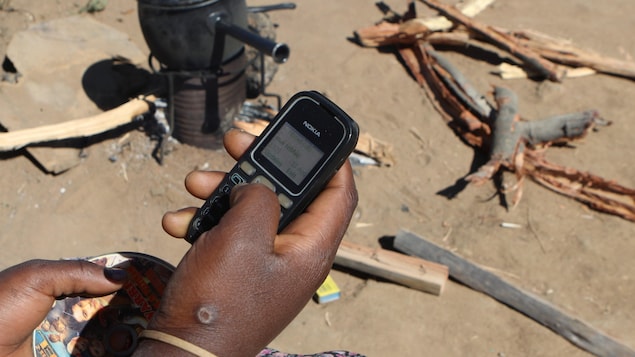 Un téléphone portable tenu par une main noire
