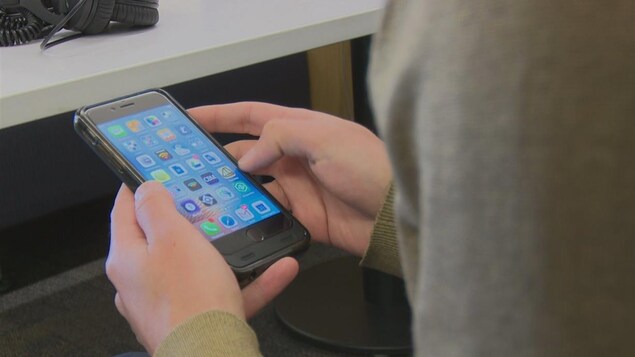 Un usager consulte son téléphone intelligent. Un usager consulte son téléphone intelligent.